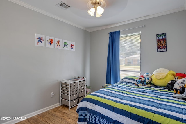 bedroom with crown molding, a ceiling fan, baseboards, wood finished floors, and visible vents