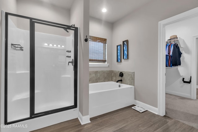 113 Spider Lily Ln, Lafayette, LA 70508 - bathroom featuring baseboards, a garden tub, wood finished floors, and a stall shower