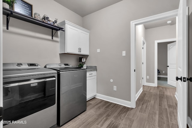 113 Spider Lily Ln, Lafayette, LA 70508 - laundry area featuring washing machine and dryer, baseboards, cabinet space, and wood finished floors