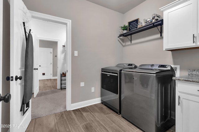 113 Spider Lily Ln, Lafayette, LA 70508 - laundry area featuring cabinet space, wood finished floors, baseboards, and washer and clothes dryer