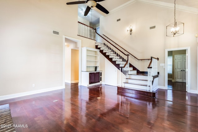 unfurnished living room with wood finished floors, visible vents, stairs, baseboards, and high vaulted ceiling