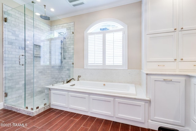 bathroom featuring a bath, visible vents, a shower stall, and ornamental molding