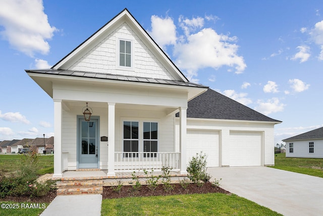 104 Manor House Ln, Lafayette, LA 70507 - view of front facade featuring concrete driveway, an attached garage, a porch, a standing seam roof, and roof with shingles