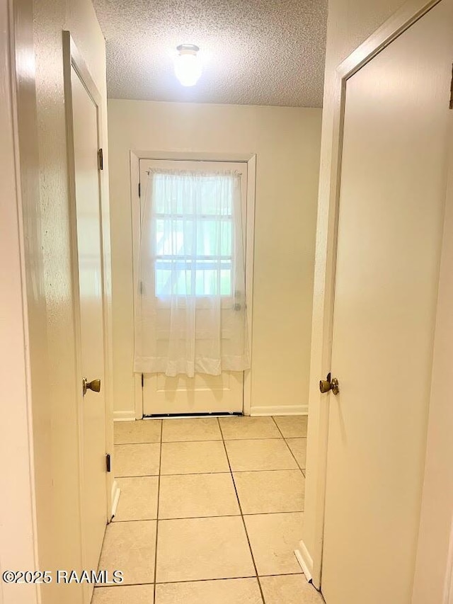 210 Essex St, Lafayette, LA 70506 - entryway featuring light tile patterned flooring, a textured ceiling, and baseboards
