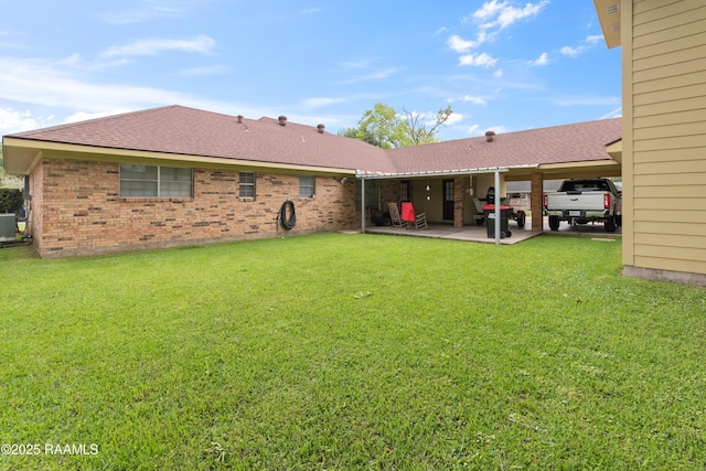 220 N Philo Dr, Lafayette, LA 70506 - back of house with a yard, brick siding, a patio area, and a shingled roof