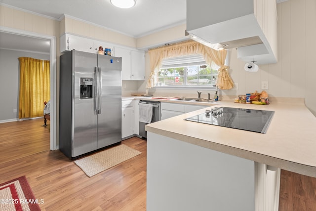 220 N Philo Dr, Lafayette, LA 70506 - kitchen with stainless steel appliances, a peninsula, light wood-style flooring, a sink, and ornamental molding