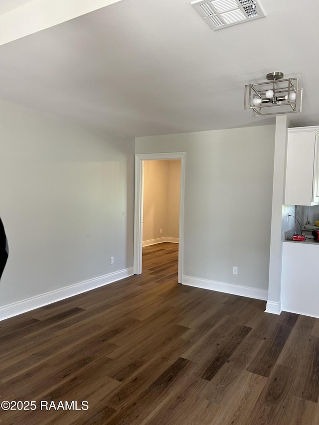 347 Marie St, Sunset, LA 70584 - unfurnished room featuring baseboards, visible vents, an inviting chandelier, and dark wood-style floors