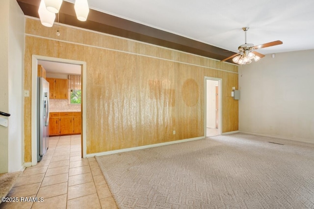221 Beverly Dr, Lafayette, LA 70503 - spare room featuring light tile patterned floors, wood walls, and ceiling fan