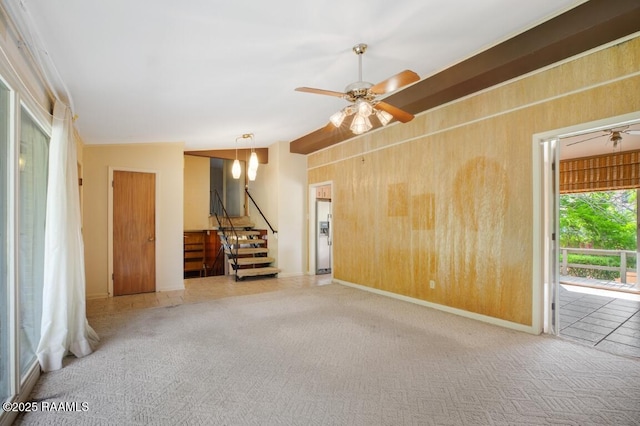 221 Beverly Dr, Lafayette, LA 70503 - carpeted empty room with wooden walls, baseboards, stairs, and ceiling fan