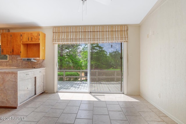 221 Beverly Dr, Lafayette, LA 70503 - unfurnished dining area with a ceiling fan, baseboards, light tile patterned floors, and crown molding
