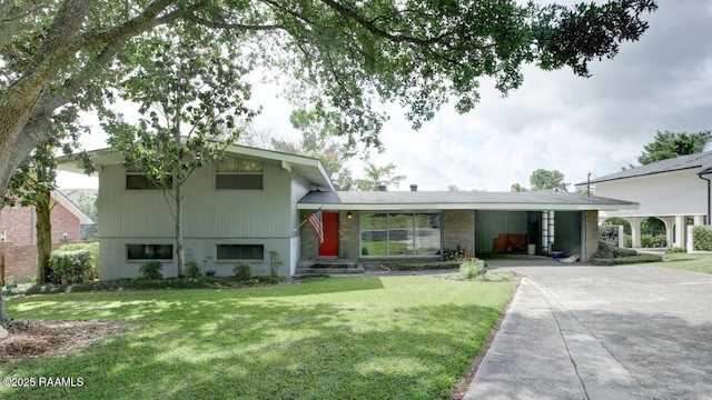 221 Beverly Dr, Lafayette, LA 70503 - tri-level home featuring concrete driveway, a front lawn, and a carport