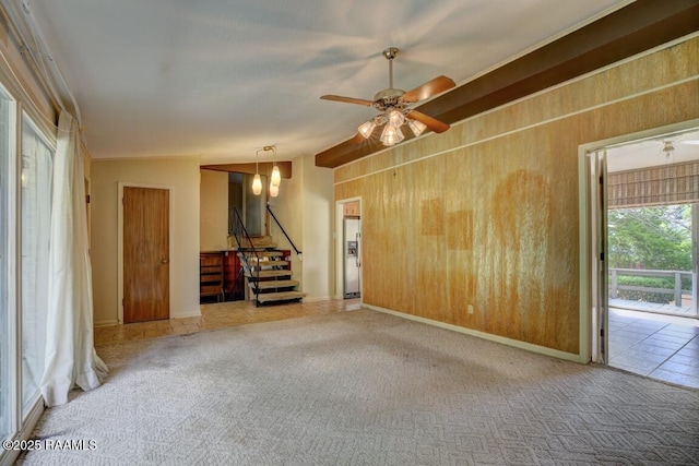 221 Beverly Dr, Lafayette, LA 70503 - carpeted spare room featuring stairway, vaulted ceiling, wooden walls, ceiling fan, and baseboards