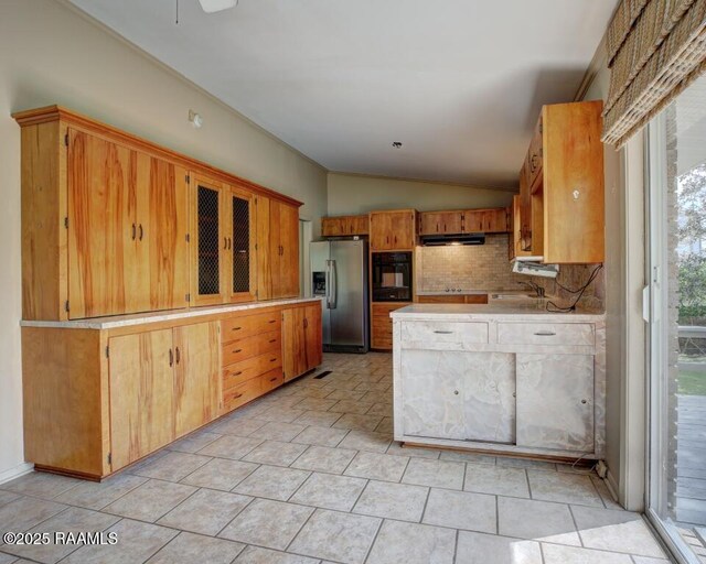 221 Beverly Dr, Lafayette, LA 70503 - kitchen featuring tasteful backsplash, stainless steel fridge, light countertops, lofted ceiling, and black oven
