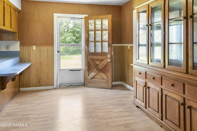 2318 Helen St, Abbeville, LA 70510 - doorway featuring baseboards, wood walls, light wood finished floors, and wainscoting