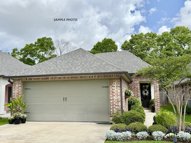 218 Berchman Oaks Dr, Lafayette, LA 70506 - ranch-style house featuring brick siding, an attached garage, a shingled roof, and concrete driveway