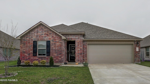 ranch-style home featuring a garage, concrete driveway, a shingled roof, a front yard, and brick siding