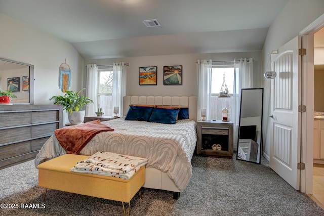 carpeted bedroom with lofted ceiling and visible vents
