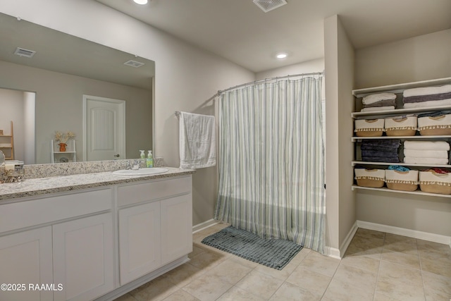 full bathroom featuring a shower with curtain, vanity, tile patterned floors, and visible vents