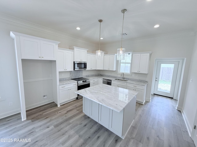 219 Berchman Oaks Dr, Lafayette, LA 70506 - kitchen featuring stainless steel appliances, a sink, a center island, white cabinets, and ornamental molding