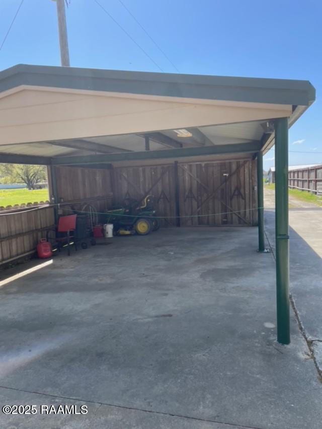 view of parking with a detached carport and concrete driveway
