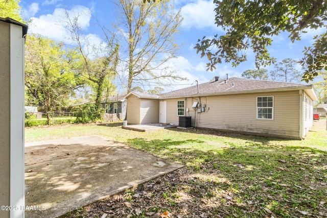 rear view of house featuring fence, a patio area, a yard, and central AC unit