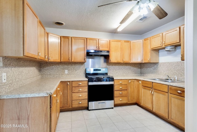 kitchen featuring under cabinet range hood, visible vents, a sink, stainless steel range with gas cooktop, and ceiling fan