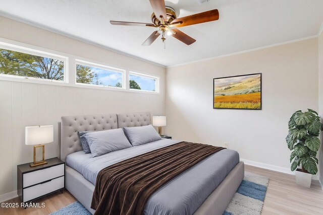 bedroom featuring light wood-type flooring, baseboards, and crown molding
