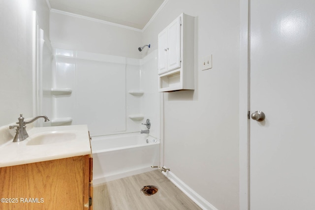 full bathroom with wood finished floors, vanity, ornamental molding, tub / shower combination, and baseboards