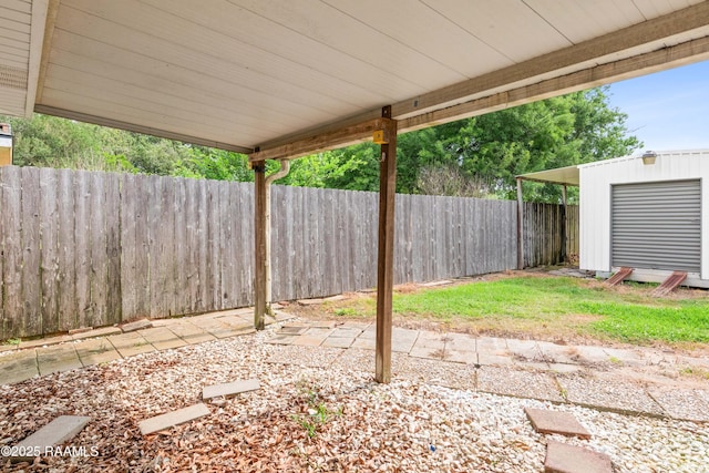 fenced backyard with a patio area, an outdoor structure, and a shed