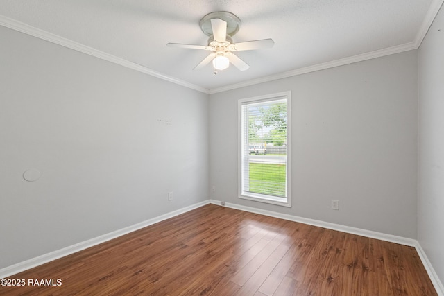 spare room featuring baseboards, wood finished floors, crown molding, and a ceiling fan