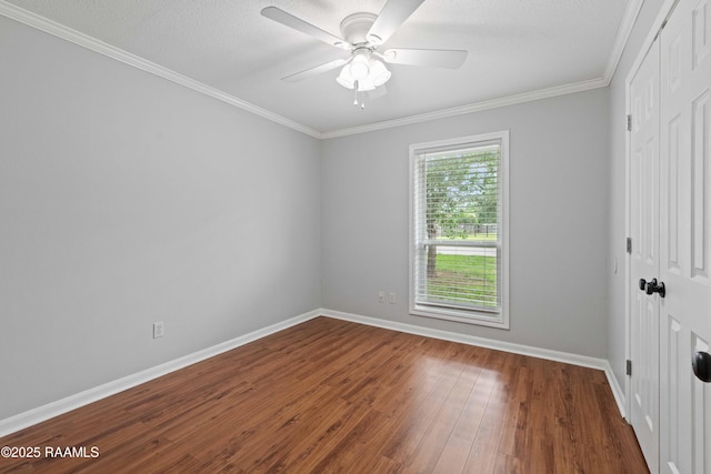 unfurnished room featuring dark wood finished floors, baseboards, ceiling fan, and ornamental molding