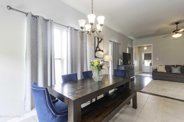 dining room featuring light tile patterned floors and ceiling fan with notable chandelier