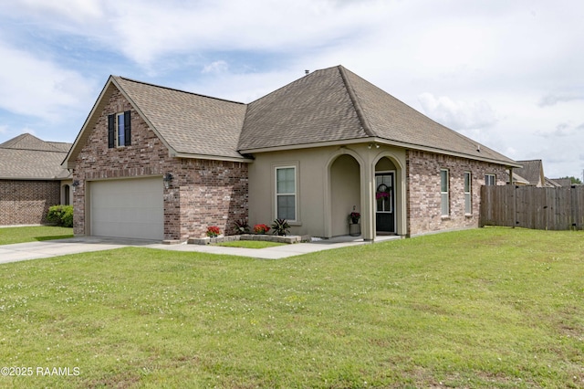 view of front facade featuring a front lawn, fence, roof with shingles, brick siding, and concrete driveway