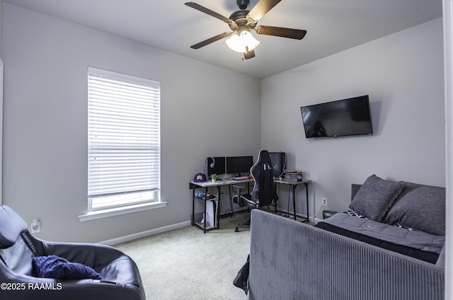 interior space featuring carpet floors, a ceiling fan, baseboards, and multiple windows