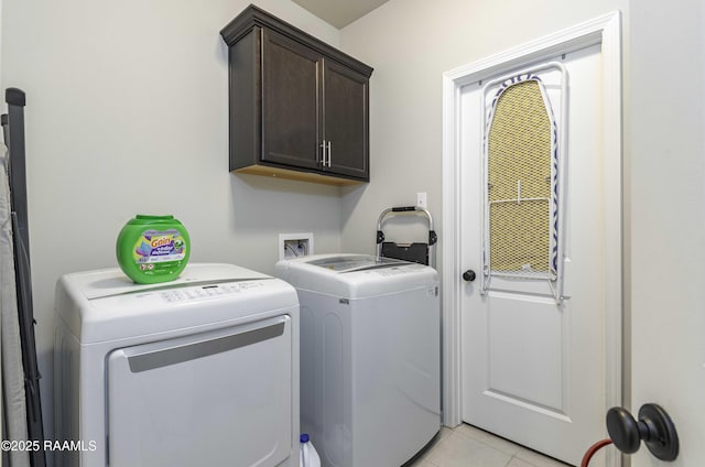 laundry room with washer and dryer, light tile patterned floors, and cabinet space