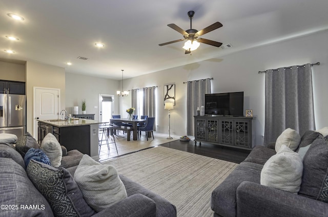 living room with recessed lighting, baseboards, visible vents, and ceiling fan with notable chandelier