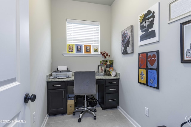 office featuring baseboards, built in desk, and light tile patterned floors