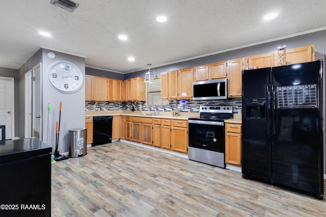 kitchen with light countertops, visible vents, a sink, and black appliances