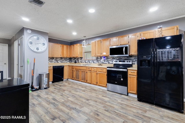 kitchen featuring black appliances, a sink, visible vents, and light countertops