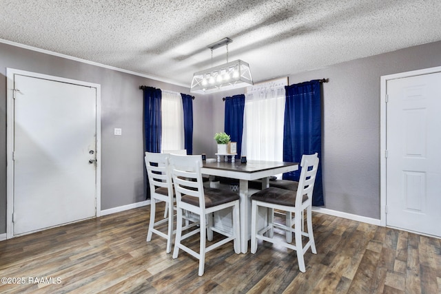 dining space featuring baseboards, crown molding, wood finished floors, and a textured ceiling