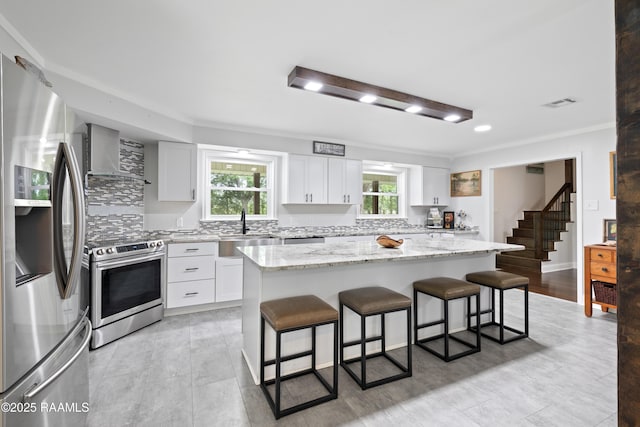 334 Meche Rd, Carencro, LA 70520 - kitchen featuring appliances with stainless steel finishes, wall chimney exhaust hood, a sink, plenty of natural light, and ornamental molding