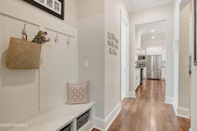 mudroom with recessed lighting, dark wood-style flooring, crown molding, and baseboards