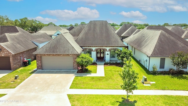 view of front of property with concrete driveway, french doors, brick siding, a front yard, and a garage