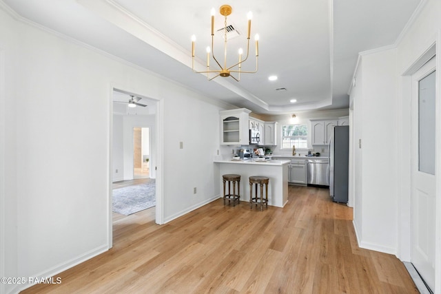kitchen with a kitchen bar, appliances with stainless steel finishes, open shelves, light wood-type flooring, and a peninsula