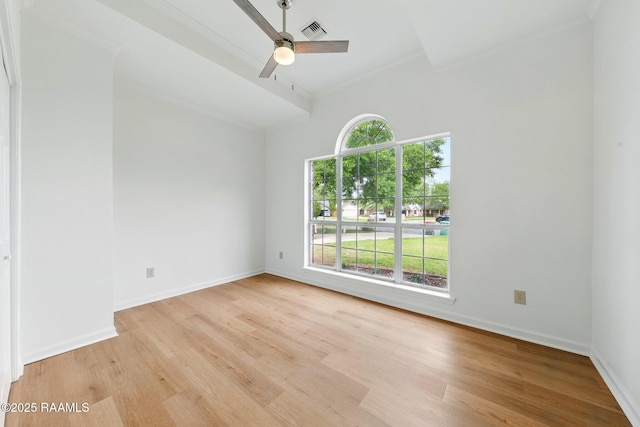 empty room with a ceiling fan, visible vents, ornamental molding, and light wood finished floors