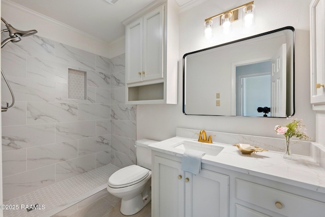 full bath with vanity, ornamental molding, a tile shower, and toilet