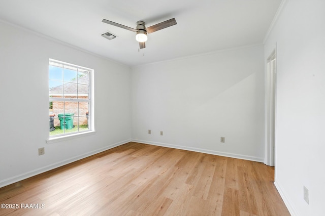 spare room with a ceiling fan, visible vents, crown molding, light wood-type flooring, and baseboards