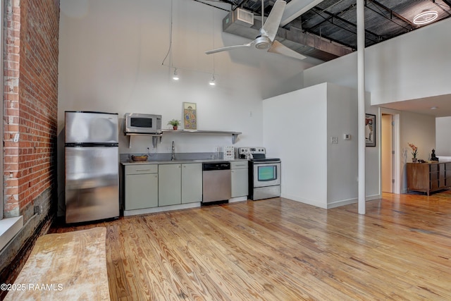 403 S Buchanan St Unit 8, Lafayette, LA 70501 - kitchen featuring appliances with stainless steel finishes, a high ceiling, light wood-style flooring, a ceiling fan, and a sink