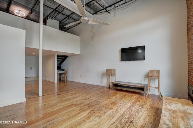 403 S Buchanan St Unit 8, Lafayette, LA 70501 - unfurnished living room with a high ceiling, wood finished floors, ceiling fan, and baseboards