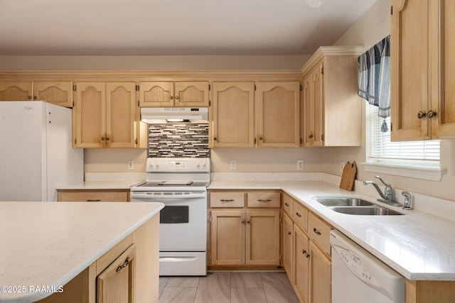 kitchen featuring white appliances, light brown cabinets, under cabinet range hood, light countertops, and a sink